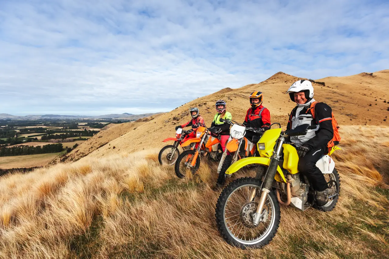 Four riders paused on high country above the plains